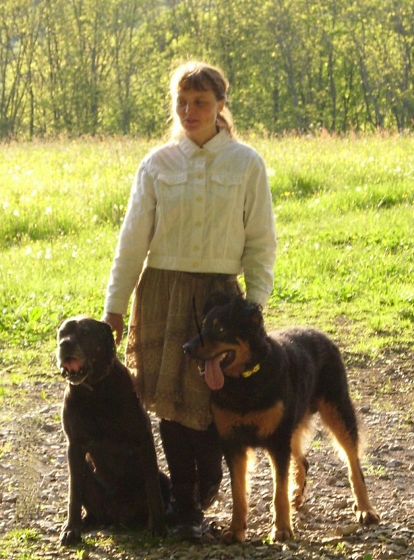 Jenni Starke steht mit ihren beiden Hunden in der Natur