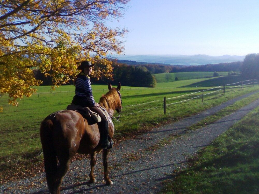 Jenni schaut auf dem Pferd in die Weite der schönen Rhön